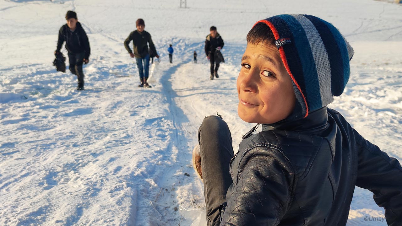 Children in Van use homemade skiing equipment
